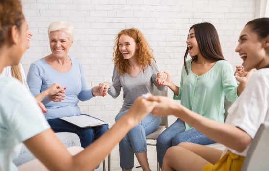 Smiling Diverse Women Sitting In Circle During Group Therapy Indoor