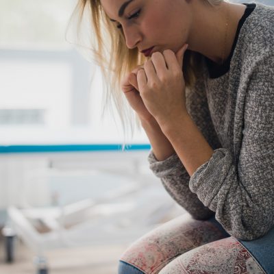 A woman sit on a hospital bed with anxiety. She was afraid of despair What she wants now is faith A woman sit on a hospital bed with anxiety. She was afraid of despair What she wants now is faith