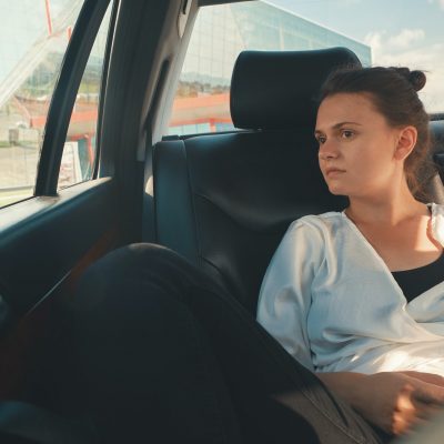 Woman is sitting in the back seat of the car Woman is sitting in the back seat of the car